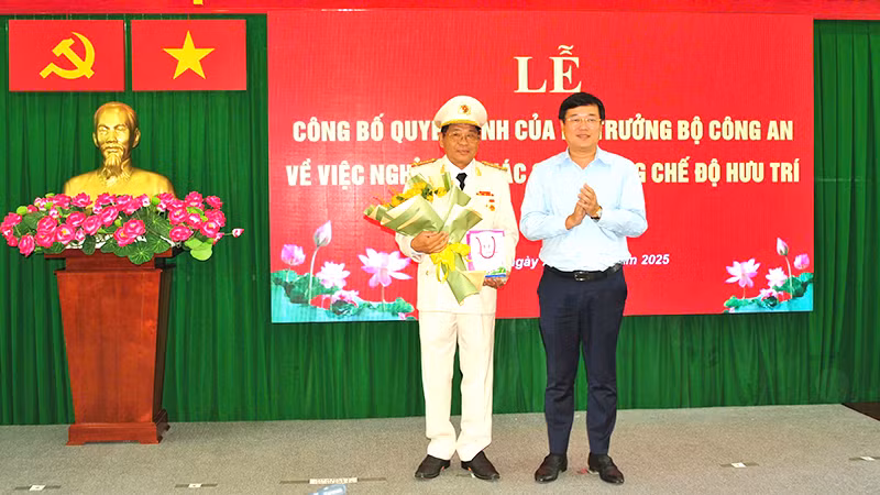 Ủy viên Trung ương Đảng, Bí thư Tỉnh ủy Đồng Tháp Lê Quốc Phong trao Huy hiệu 40 năm tuổi Đảng và tặng hoa chúc mừng Đại tá Nguyễn Văn Hiểu. (Ảnh: Công an cung cấp)