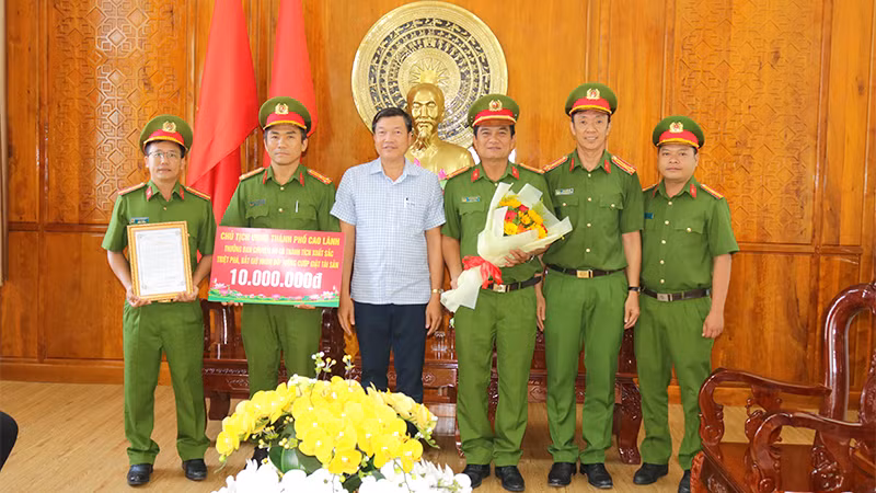 Chủ tịch Ủy ban nhân dân thành phố Cao Lãnh Võ Phan Thành Minh trao thưởng cho Ban chuyên án. (Ảnh: PHƯỚC THANH)