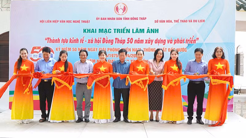 Nghi thức cắt băng khai mạc triển lãm ảnh. (Ảnh: NHƯ ANH)