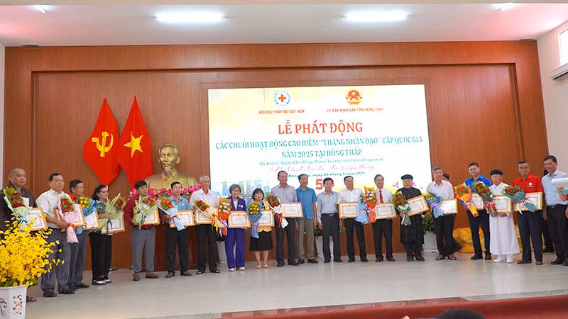 Tặng hoa cảm ơn các đơn vị đã đóng góp nguồn lực thực hiện công trình, phần việc nhân đạo ở địa phương. (Ảnh: HỮU NGHĨA)