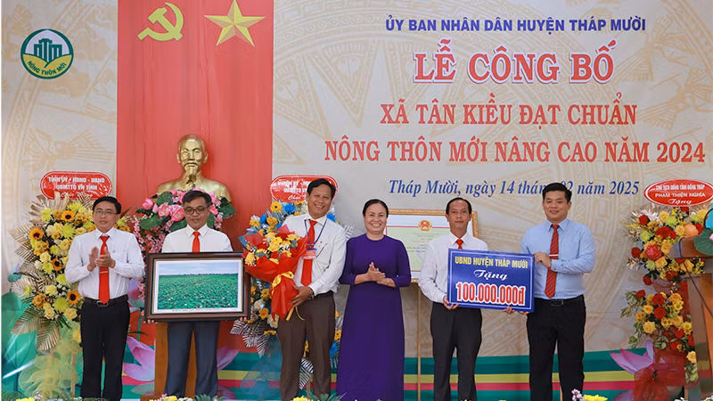Lãnh đạo Huyện ủy, Ủy ban nhân dân huyện Tháp Mười trao bảng tượng trưng công trình phúc lợi trị giá 100 triệu đồng và tặng hoa chúc mừng. (Ảnh: HOÀNG KHA) Lãnh đạo Huyện ủy, Ủy ban nhân dân huyện Tháp Mười trao bảng tượng trưng công trình phúc lợi trị giá 100 triệu đồng và tặng hoa chúc mừng. (Ảnh: HOÀNG KHA)