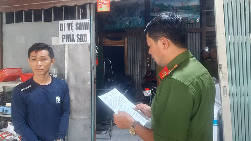 Nguyễn Hữu Toàn nghe đọc lệnh bắt. (Ảnh: Công an Đồng Tháp)