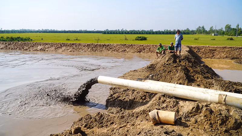 Cát đang được bơm vào công trường cao tốc. (Ảnh: HỮU NGHĨA)
