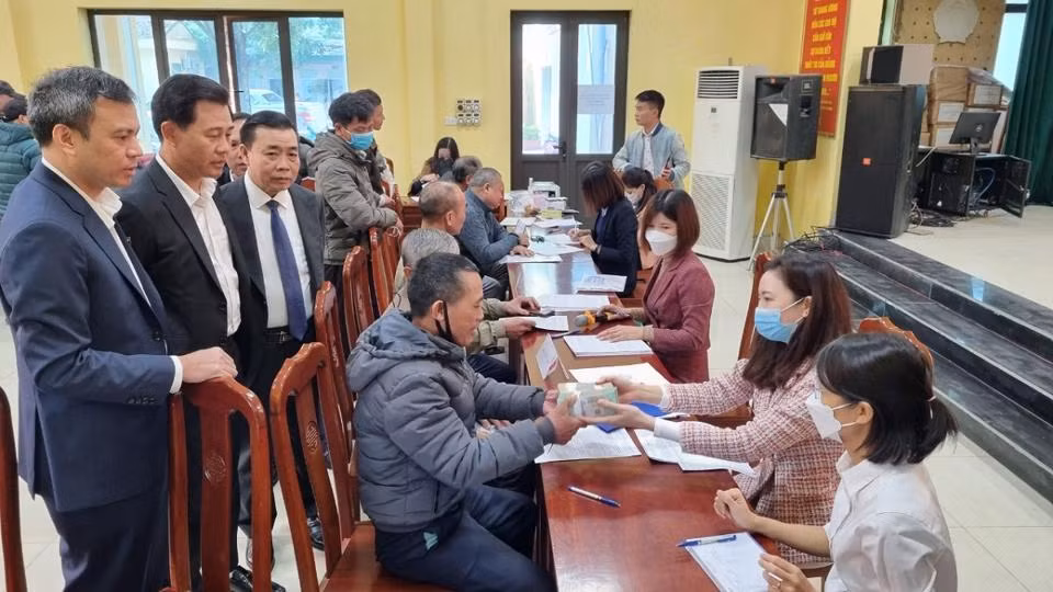 Người dân xã Song Phương đến nhận tiền hỗ trợ bồi thường.