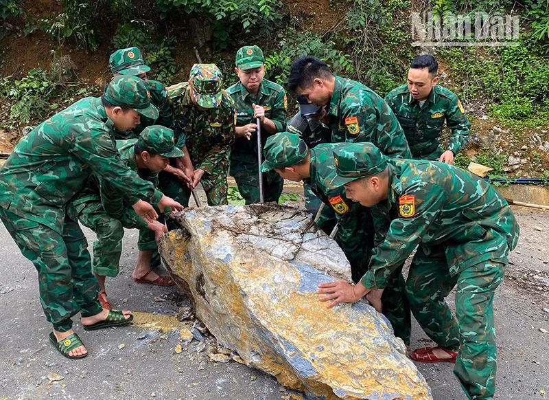 Cán bộ, chiến sĩ Đồn Biên phòng Chiềng Tương, Bộ đội Biên phòng tỉnh Sơn La khắc phục tuyến đường bị đá sạt lở chắn ngang.