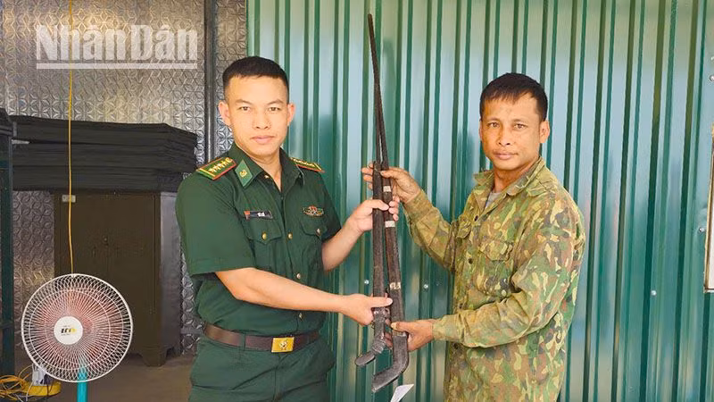 Cán bộ Đồn Biên phòng Mường Cai tiếp nhận 2 khẩu súng tự chế.