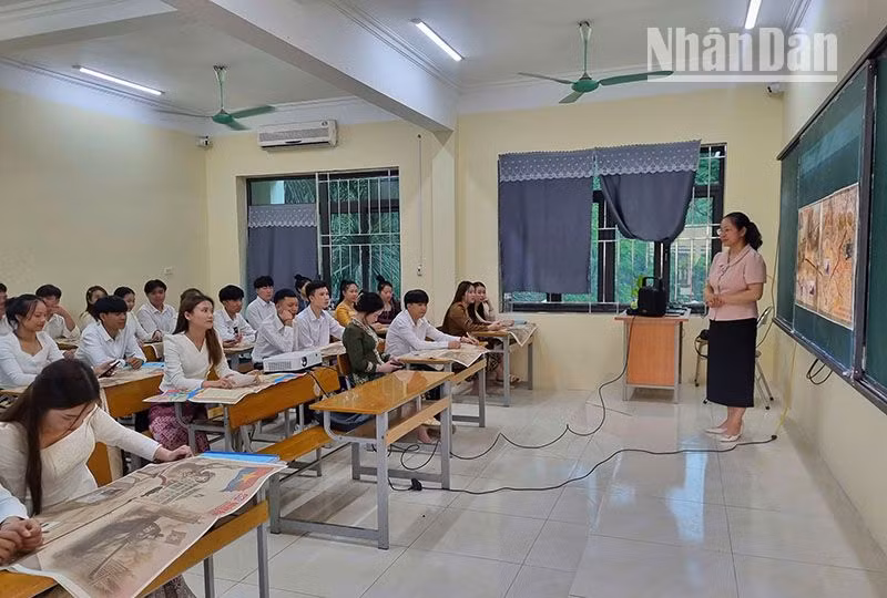 Trong giờ học tiếng Việt, giáo viên đã giới thiệu cho các lưu học sinh Lào về nội dung của ấn phẩm đặc biệt của Báo Nhân Dân.