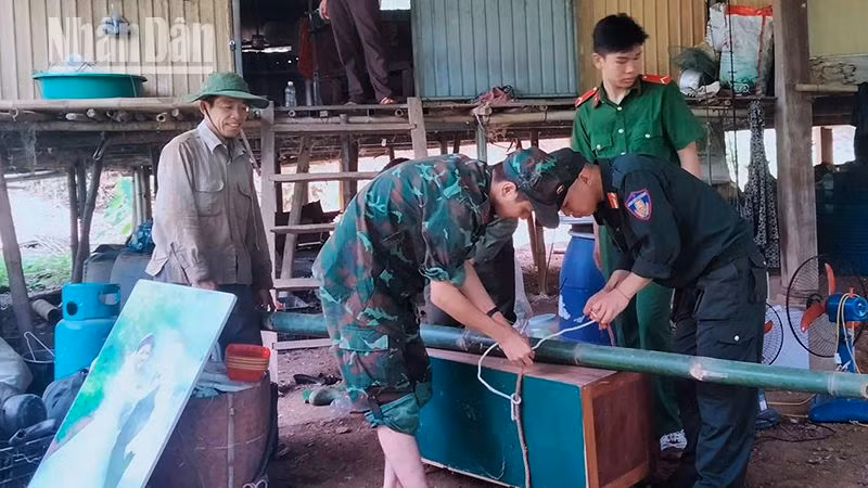 Các lực lượng của huyện Bắc Yên hỗ trợ, giúp người dân bản Ngậm, xã Song Pe di chuyển tài sản đến nơi an toàn. (Ảnh: A CHỚ)