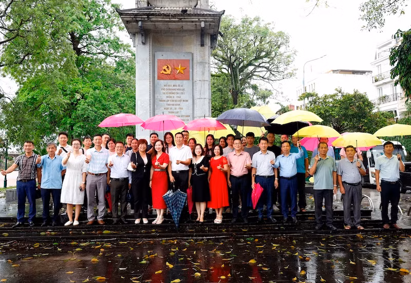 Đại biểu của 2 địa phương chụp ảnh lưu niệm tại Di tích Biểu tượng nơi thành lập Chi bộ Đảng cộng sản Việt Nam đầu tiên của huyện Hải Ninh (Tiền thân của Đảng bộ thành phố Móng Cái ngày nay).