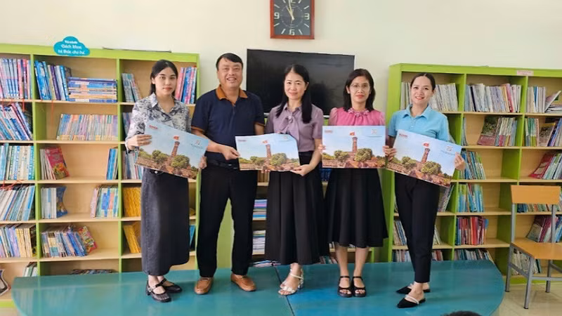 Đại diện Văn phòng Báo Nhân Dân tại tỉnh Quảng Ninh tặng ấn phẩm đặc biệt "Cột cờ Hà Nội" cho Trường tiểu học thị trấn Đầm Hà, Quảng Ninh.