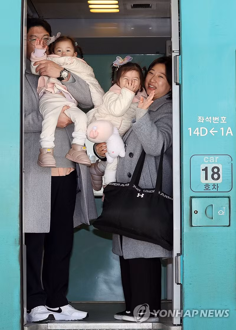 Một gia đình lên tàu tại nhà ga Seoul, Hàn Quốc, để trở về quê hương. Ngày nay, đa số người Hàn Quốc đều chào đón ngày đầu tiên của năm mới vào Tết Dương lịch (ngày 1/1 dương lịch), nhưng họ vẫn duy trì truyền thống sum vầy bên nhau dịp Tết âm lịch. Ảnh: YONHAP