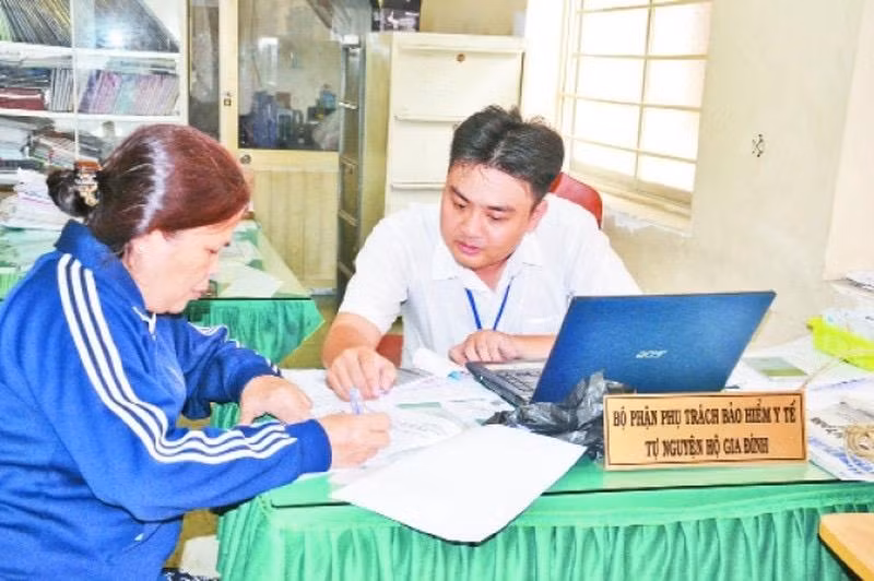 Học tập và làm theo phong cách Hồ Chí Minh, cán bộ phường 9, quận 11 tận tình hướng dẫn người dân thủ tục mua bảo hiểm y tế tự nguyện hộ gia đình.