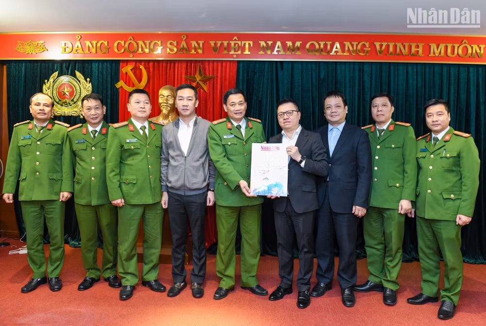 Tổng Biên tập Báo Nhân Dân Lê Quốc Minh (thứ 4 từ phải sang) và các đồng chí trong đoàn công tác trao tặng Báo Nhân Dân Xuân Quý Mão 2023 đến các cán bộ, chiến sĩ Cục Cảnh sát điều tra tội phạm về tham nhũng, kinh tế, buôn lậu. (Ảnh: THÀNH ĐẠT)