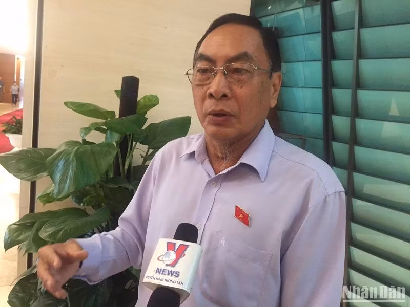 Đại biểu Phạm Văn Hòa trao đổi bên hành lang Quốc hội. (Ảnh: VĂN TOẢN)