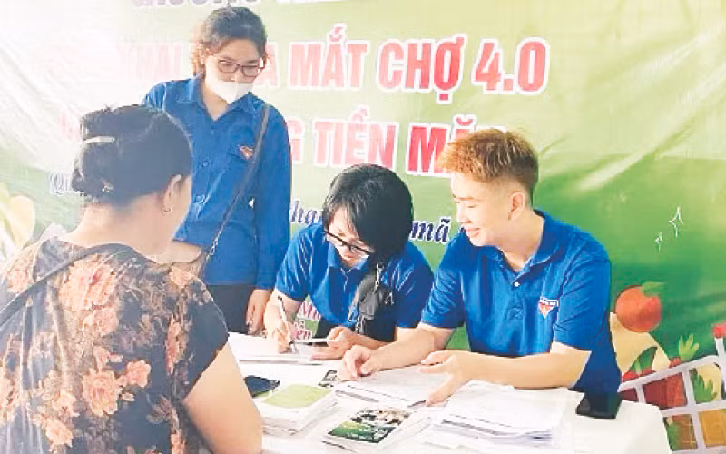 Đoàn viên thanh niên hướng dẫn tiểu thương mở tài khoản và cách thanh toán không dùng tiền mặt.