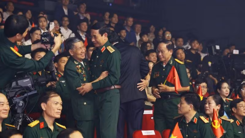Đại tướng Phan Văn Giang, Bộ trưởng Quốc phòng, gặp gỡ, bắt tay các cựu chiến binh tham dự chương trình cầu truyền hình tại điểm cầu Hà Nội. (Ảnh: ĐỖ THOA)
