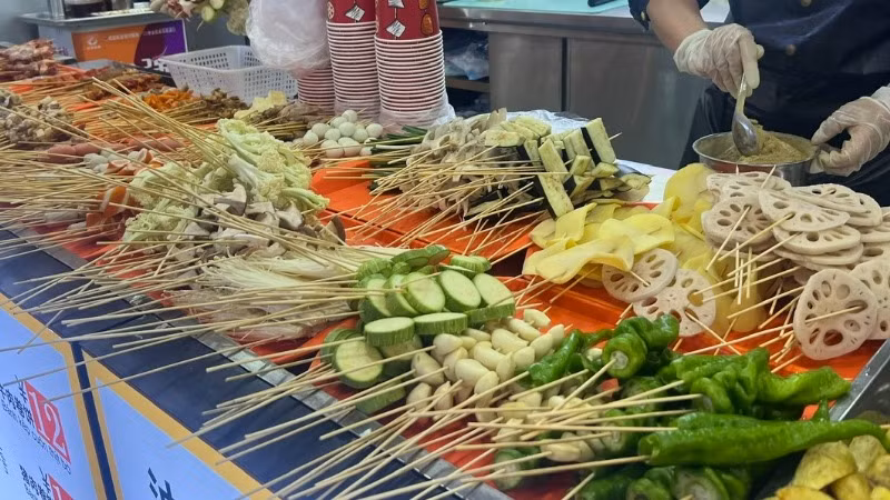 Các quán hàng bán xiên nướng (thịt, cá, hải sản, rau củ xiên que) ven đường tiềm ẩn nhiều nguy cơ mất an toàn vệ sinh thực phẩm. (Ảnh: Cục An toàn thực phẩm)