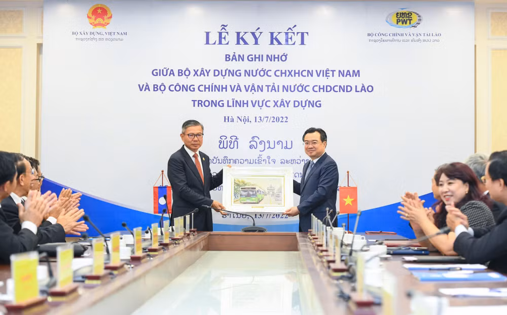 Bộ trưởng Công chính và Vận tải Lào Viengsavath Siphandone (bên trái) tặng quà lưu niệm Bộ Xây dựng Việt Nam. (Ảnh: Thành Đạt)