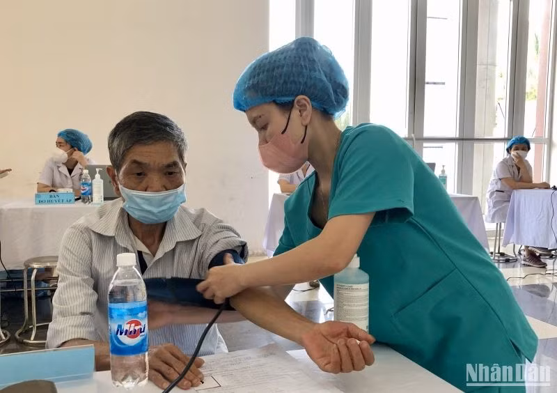 Các cán bộ y, bác sĩ thăm khám sức khỏe cho người dân trên địa bàn huyện Mê Linh.