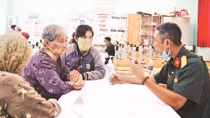Bác sĩ quân y Phạm Văn Dũng (Cục 12) khám chữa bệnh cho người có công. (Ảnh ANH THẾ)