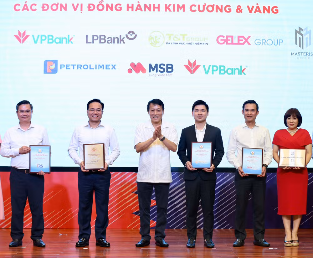 Phó Chủ tịch Hội đồng quản trị T&T Group Đỗ Vinh Quang (thứ ba từ phải sang) nhận bảng danh vị nhà đồng hành Kim Cương từ Hiệp hội thể thao CAND. Phó Chủ tịch Hội đồng quản trị T&T Group Đỗ Vinh Quang (thứ ba từ phải sang) nhận bảng danh vị nhà đồng hành Kim Cương từ Hiệp hội thể thao CAND.