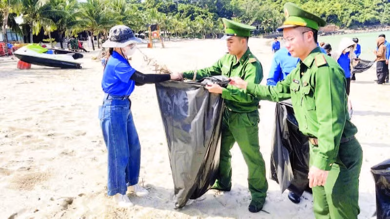 Cán bộ, chiến sĩ Biên phòng Cửa khẩu cảng Đà Nẵng cùng đoàn viên, thanh niên thành phố thu gom rác làm sạch bãi biển Đà Nẵng.