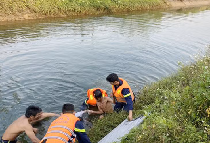 Lực lượng chức năng vớt thi thể anh P. dưới kênh thủy lợi Phú Ninh. 