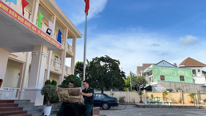 Thượng úy Nguyễn Văn Đức (bên phải), Đội trưởng đội vận động quần chúng tìm hiểu lịch sử dưới lá cờ Tổ quốc.
