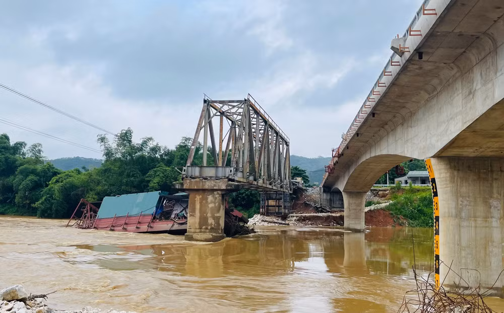 Chiếc tàu cuốc bị mắc kẹt vào trụ cầu Tô Mậu cũ đang trong quá trình tháo dỡ. (Ảnh: THANH SƠN)