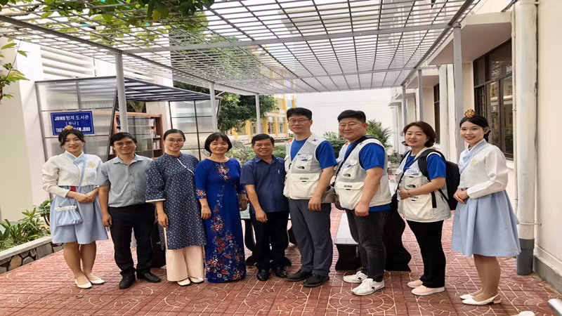 Đại diện hai trường chụp ảnh kỷ niệm tại thư viện ngoài trời.