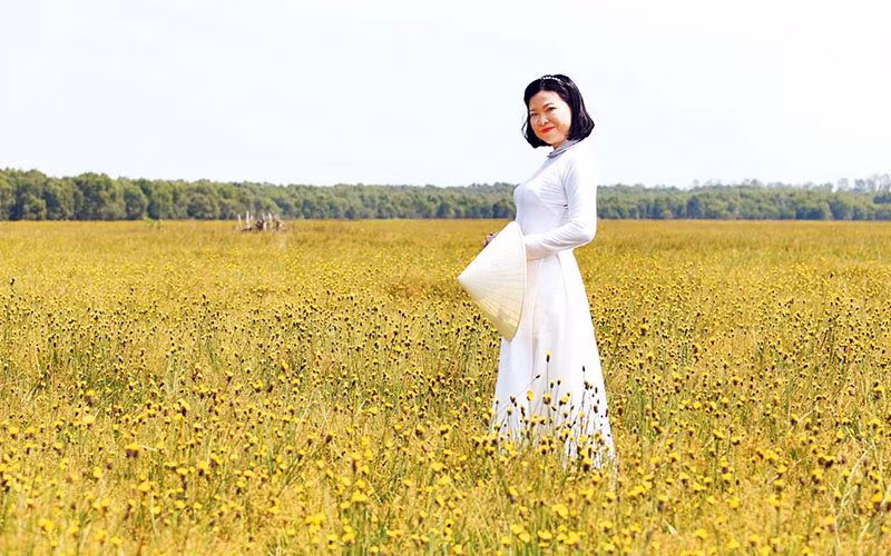 Du khách với hoa hoàng đầu ấn. (Ảnh LÊ THÀNH TRÍ)