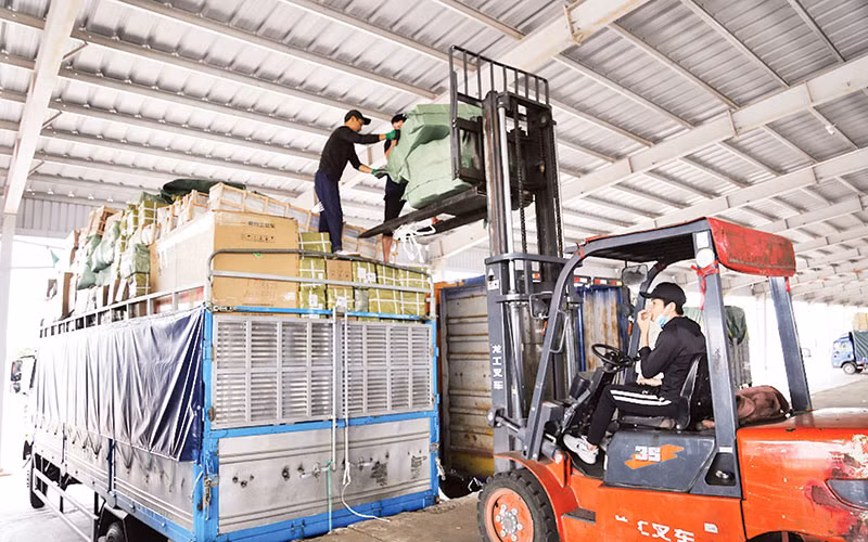 Bốc xếp hàng hóa tại bãi kiểm lối mở cầu phao tạm Km3+4 Hải Yên, Móng Cái.