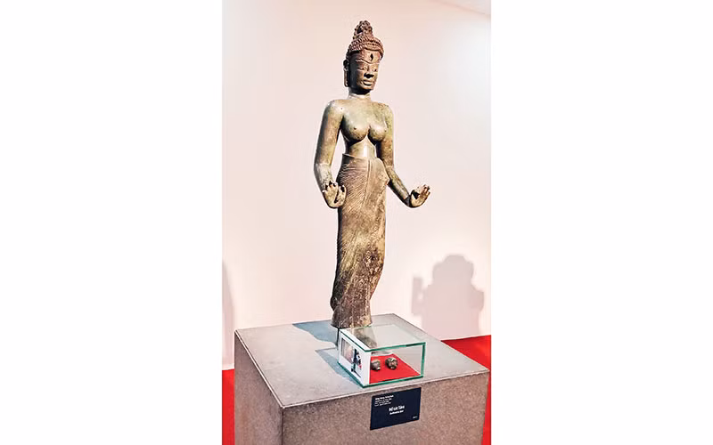 Tượng Bồ tát Tara và hai di vật đóa sen và con ốc trong hộp kính đặt dưới chân tượng. (Ảnh do Bảo tàng Điêu khắc Chăm cung cấp)