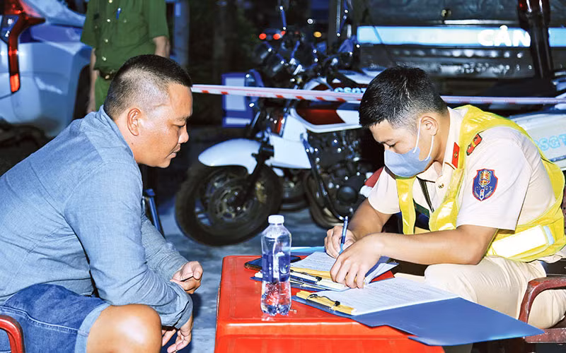 Lực lượng Công an tỉnh Đồng Nai lập biên bản xử lý lái xe vi phạm trật tự an toàn giao thông trên Quốc lộ 20.