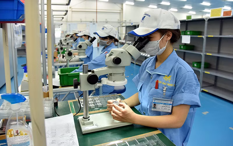 Công nhân làm việc tại dây chuyền sản xuất linh kiện cơ khí siêu chính xác tại công ty TNHH Fujikin Bắc Ninh (Khu công nghiệp VSIP Bắc Ninh). (Ảnh ANH SƠN)