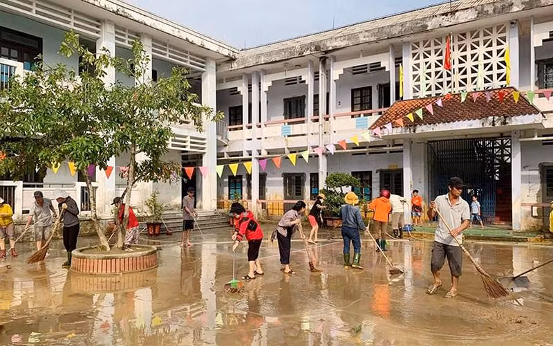 Giáo viên và phụ huynh Trường tiểu học-THCS Hải Hòa (huyện Hải Lăng, tỉnh Quảng Trị) dọn vệ sinh trường lớp để đón học sinh trở lại vào sáng 19/10. (Ảnh QUANG HUY)