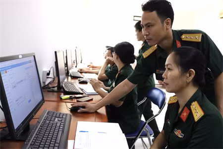 Cán bộ Ban Công nghệ thông tin Quân khu 7 hướng dẫn cán bộ, nhân viên Cục Chính trị Quân khu sử dụng phần mềm hệ thông tin chỉ đạo, điều hành.
