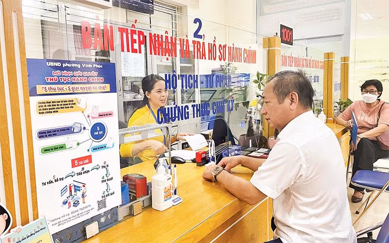 Người dân đến làm thủ tục hành chính tại Bộ phận một cửa phường Vĩnh Phúc, quận Ba Đình. (Ảnh THỦY TIÊN)