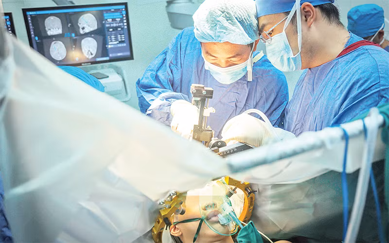 Các bác sĩ Bệnh viện Hữu nghị Việt Đức thực hiện thành công ca phẫu thuật kích thích não sâu cho bệnh nhân rối loạn trương lực cơ toàn thể. (Ảnh NGỌC ĐỨC)