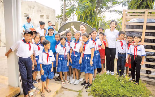 Chị Nguyễn Hồng Hạnh, cán bộ nước sạch, vệ sinh môi trường - UNICEF Việt Nam (áo xanh, bên trái) và cán bộ Masterise Group chia sẻ niềm vui với các em học sinh Trường tiểu học Long Phú C khi đón thiết bị nhà vệ sinh không phát thải. Chị Nguyễn Hồng Hạnh, cán bộ nước sạch, vệ sinh môi trường - UNICEF Việt Nam (áo xanh, bên trái) và cán bộ Masterise Group chia sẻ niềm vui với các em học sinh Trường tiểu học Long Phú C khi đón thiết bị nhà vệ sinh không phát thải.