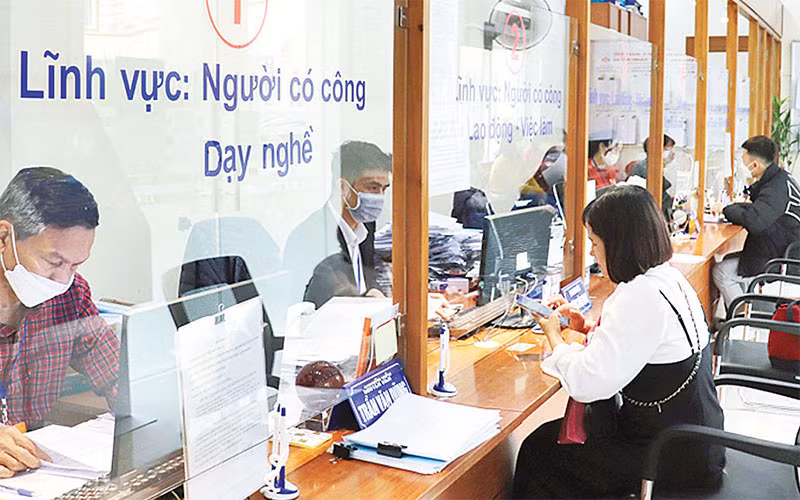 Giải quyết thủ tục hành chính cho người dân tại Bộ phận một cửa Sở Lao động-Thương binh và Xã hội Hà Nội. (Ảnh Quang Thái)