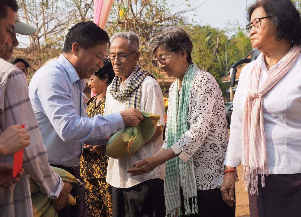 Đại sứ Nguyễn Huy Tăng trao quà cho người đến khám bệnh. (Ảnh: Nguyễn Hiệp)