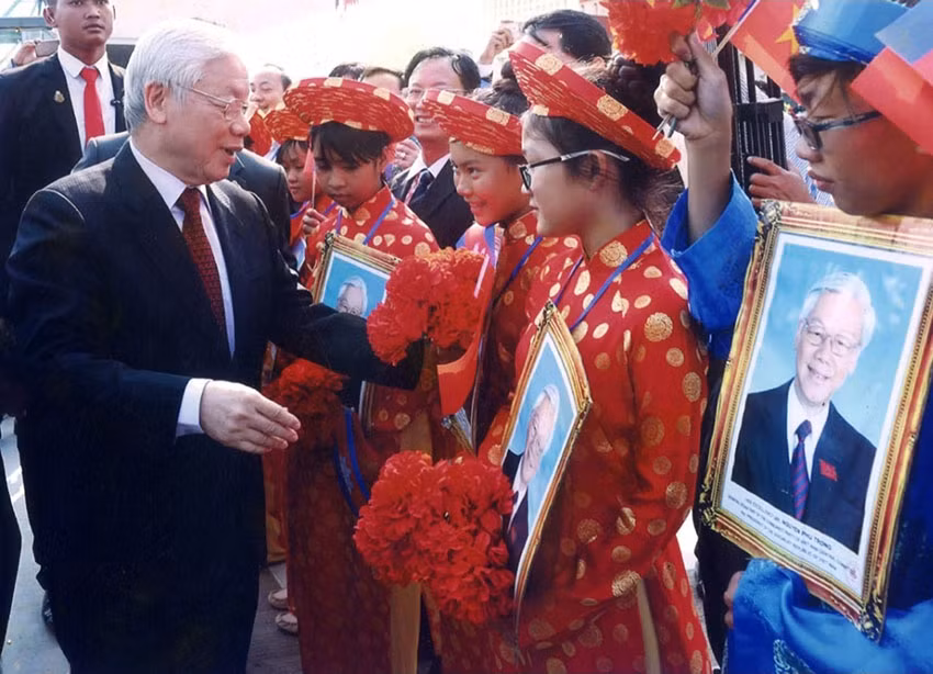 Tổng Bí thư Nguyễn Phú Trọng hỏi thăm các cháu thiếu nhi là con em người gốc Việt Nam tại Campuchia. (Ảnh: Hội Khmer-Việt Nam cung cấp)