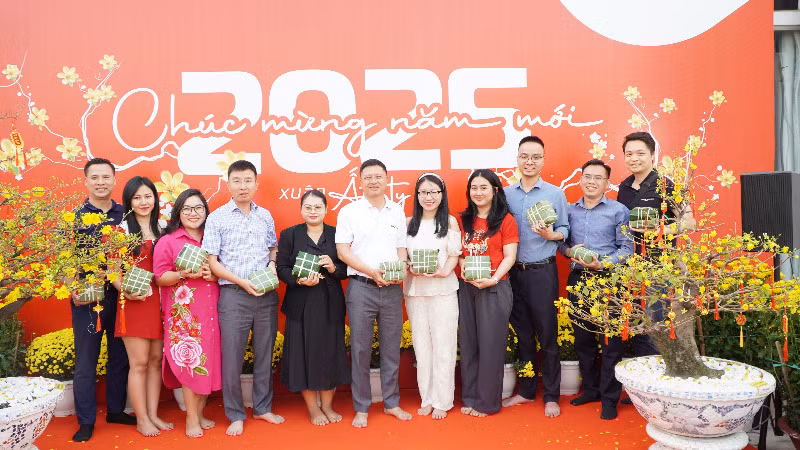 Tổng Giám đốc Metfone Cao Mạnh Đức (giữa) và đại diện các đội tham gia thi gói bánh chưng chia sẻ sản phẩm của nhóm mình. (Ảnh: HUY VŨ)