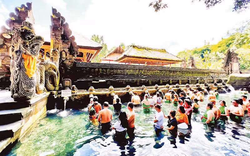 Người dân và du khách xếp hàng chờ đến lượt thực hiện nghi thức tắm nước suối thiêng ở đền Tirta Empul.