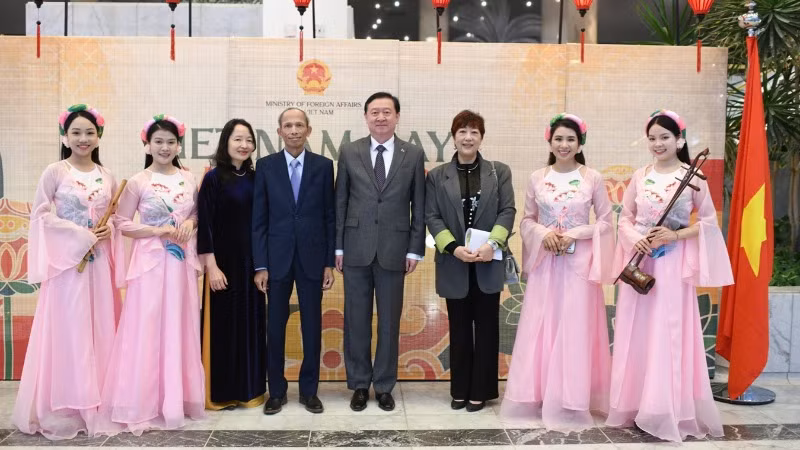 Đại sứ Việt Nam và phu nhân cùng Đại sứ Trung Quốc và phu nhân chụp ảnh lưu niệm với các nghệ sĩ nhạc dân tộc.