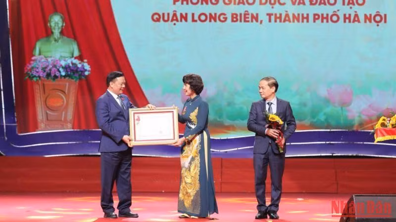 Đồng chí Đinh Tiến Dũng trao Huân chương Lao động hạng Nhất cho Phòng Giáo dục và Đào tạo quận Long Biên. (Ảnh: THANH TÙNG) 