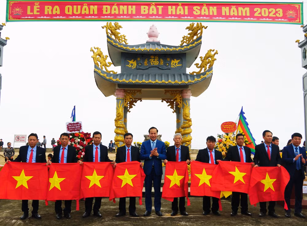 Lãnh đạo huyện Quảng Trạch tặng cờ Tổ quốc cho ngư dân.