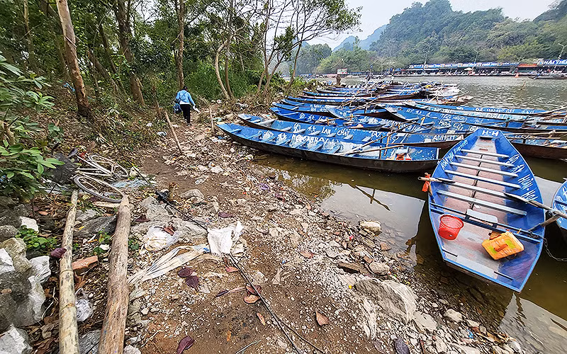 “Bến đò” mà “cò” dẫn chúng tôi vào: một bãi đất ven suối Yến với rác thải, phế liệu chất bừa bãi ngay cạnh hàng trăm chiếc thuyền đỗ lộn xộn. “Bến đò” mà “cò” dẫn chúng tôi vào: một bãi đất ven suối Yến với rác thải, phế liệu chất bừa bãi ngay cạnh hàng trăm chiếc thuyền đỗ lộn xộn.