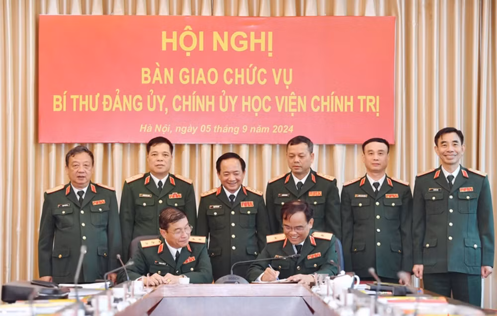 Thượng tướng Trịnh Văn Quyết và các đại biểu chứng kiến Trung tướng Trương Thiên Tô và Thiếu tướng Nguyễn Bá Hùng ký kết biên bản bàn giao. (Ảnh: Báo Quân đội nhân dân)